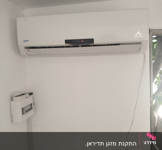 מזגן מותקן על קיר עם כבלים חשמליים
